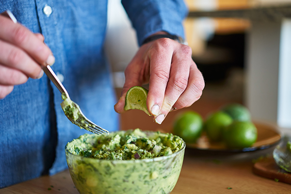 adding lime juice to guacamole shot with selective focus close up